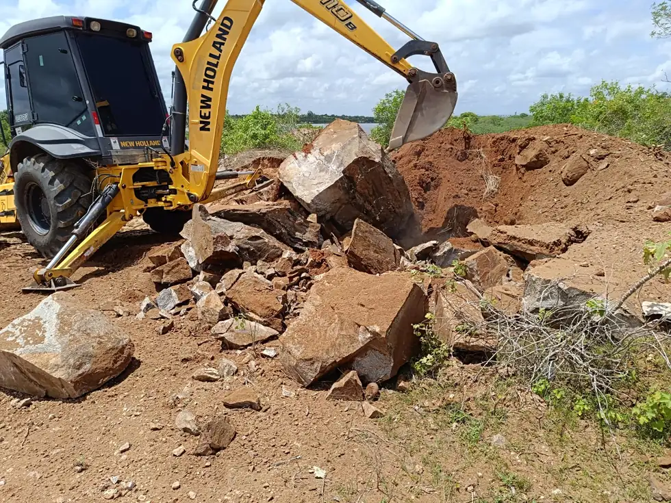 Retroescavadeira removendo rocha fragmentada da cava
