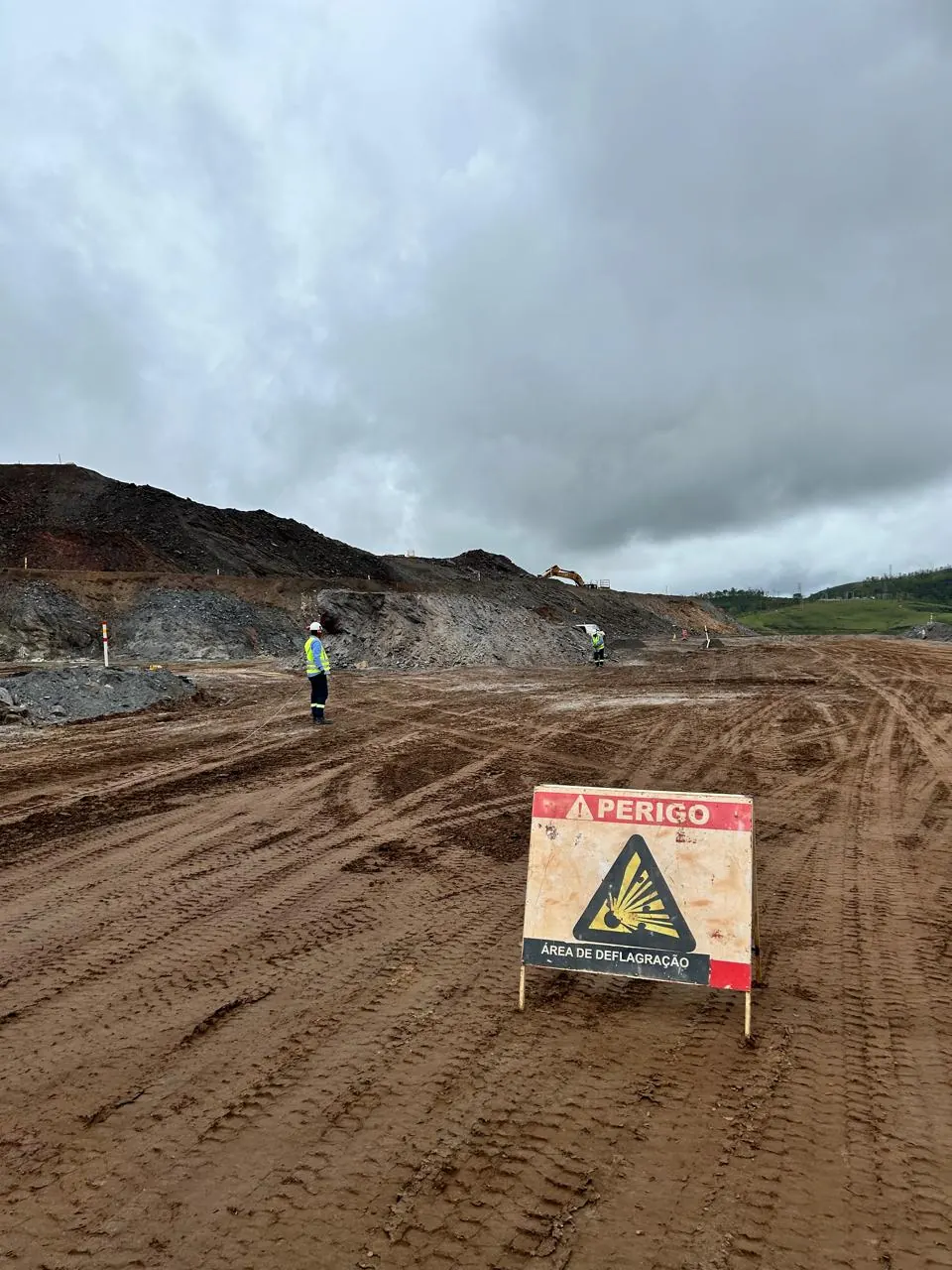Placa de sinalização de área de deflagração isolando a frente de desmonte