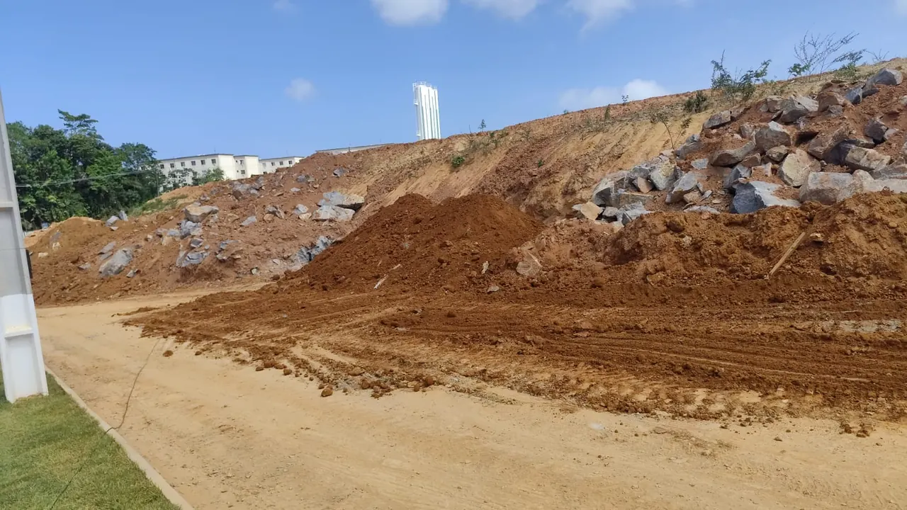 Escavadeira removendo a rocha fragmentada do terreno rebaixado