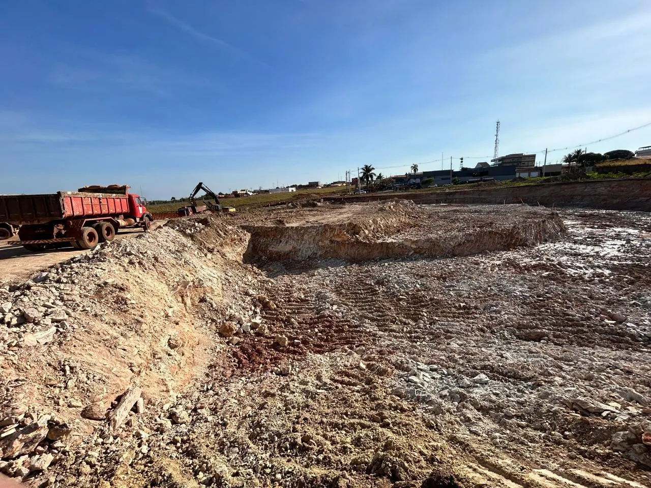 Desmonte de rocha em área urbana com casas e galpões no entorno