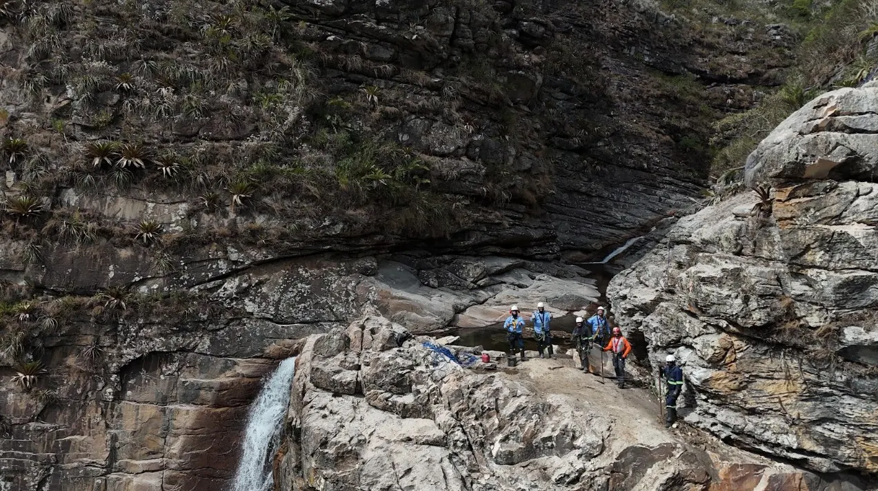 Equipe reunida na crista da cachoeira, junto à queda d'água